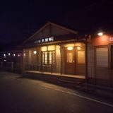 独立民谣歌手在Livehouse小舞台演唱，抱着吉他，灯光昏黄，观众近距离聆听
